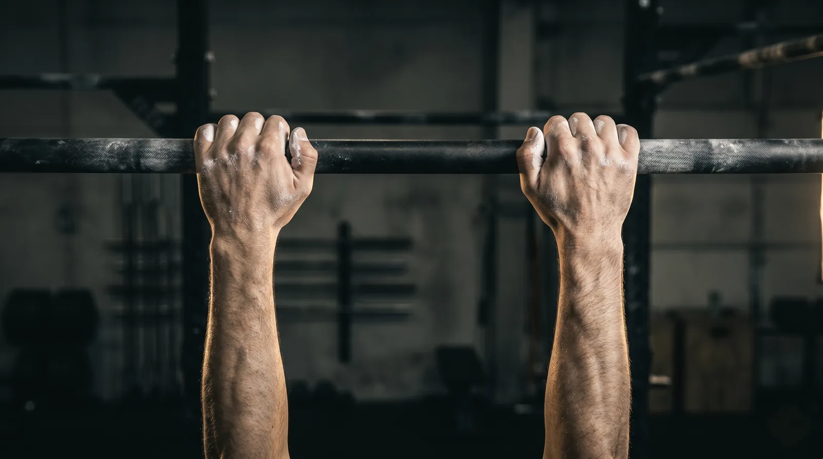 Mains d'un candidat en prise de pronation sur une barre de traction : paumes tournées vers l'avant, dos des mains face à l'objectif.